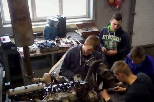 uczniowie w czasie naprawy silnika ciągnika